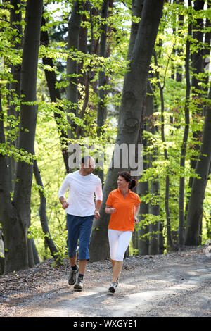 Couple jogging en forêt de hêtres Banque D'Images