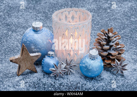 Avènement naturel décoration : une bougie allumée dans une lampe-dans la neige, entouré de lumière boules bleues. La Suisse Banque D'Images