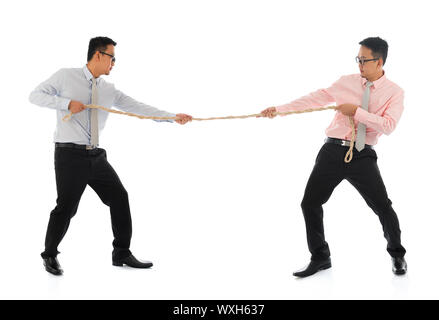 Deux corps plein d'affaires Asiatique tirant une corde, isolé sur fond blanc. Modèle masculin d'Asie. Banque D'Images