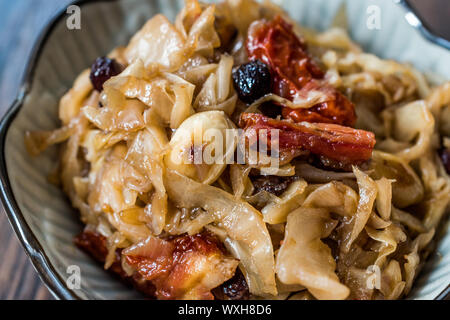 Salade de chou avec oignons caramélisés, les tomates séchées et les raisins de Corinthe. Aliments biologiques traditionnelles. Banque D'Images