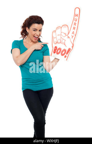 Smiling young woman pointing at large main mousse contre isolé sur fond blanc Banque D'Images