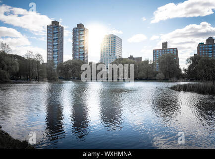 Une photo de Central Park lors d'une belle journée ensoleillée, avec ses bâtiments reflétant dans l'eau d'un lac. La ville de New York, United States Banque D'Images