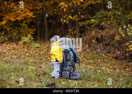 Lonely Boy holding mère attendant kid carrier Banque D'Images