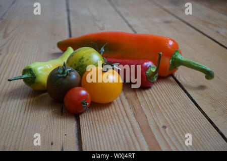 Ensemble de longue multicolore de poivrons et tomates heirloom sur une table en bois rustique Banque D'Images