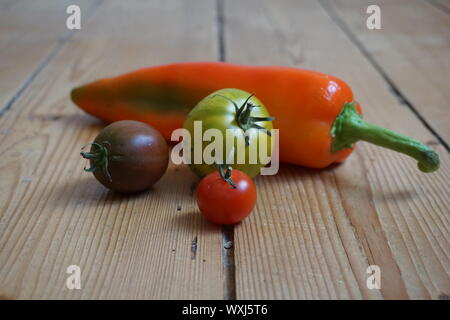 Ensemble de longue multicolore de poivrons et tomates heirloom sur une table en bois rustique Banque D'Images