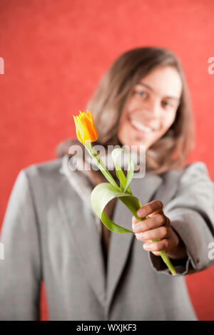 Closeup Portrait of a Handsome Young man with Yellow Tulip Banque D'Images