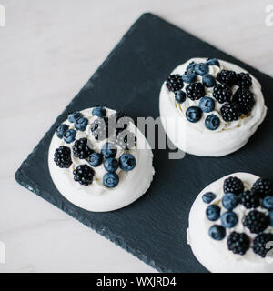 Vue de dessus de Pavlova desserts avec les bleuets et les mûres sur ardoise Banque D'Images