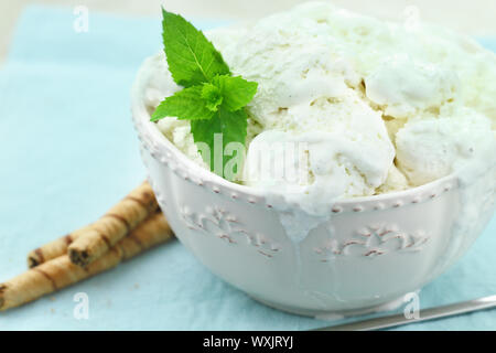 Crème glacée à la vanille avec un brin de menthe fraîche et chocolat des pirouettes. Banque D'Images