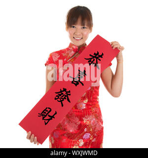 Femme Asiatique avec une robe traditionnelle chinoise ou qipao cheongsam holding couplet, le mot chinois signifie félicitations et meilleurs vœux de prospérité Banque D'Images