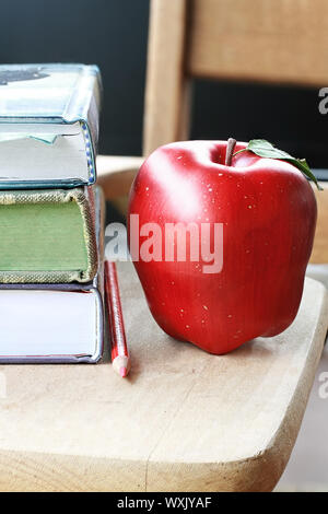 Les livres scolaires avec apple et crayon rouge sur 24. Banque D'Images