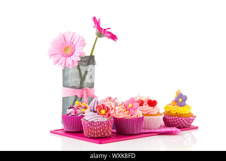 Cupcakes colorés sur bac rose avec fleurs d'anniversaire Banque D'Images