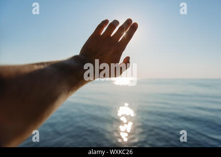 La main de l'homme atteindre pour le soleil Banque D'Images