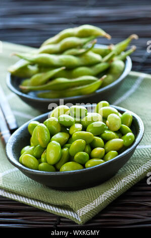 Les fèves de soja Edamame écossées et avec pods dans des bols Banque D'Images