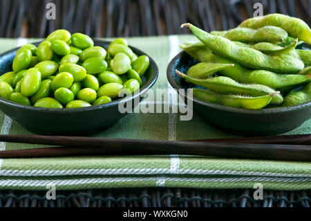 Les fèves de soja Edamame écossées et avec pods dans des bols Banque D'Images
