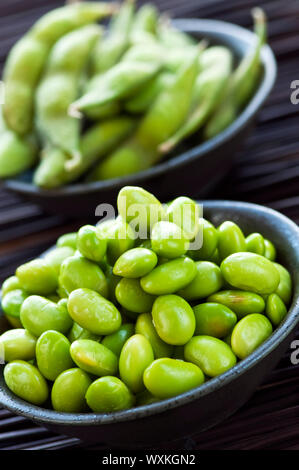 Les fèves de soja Edamame écossées et avec pods dans des bols Banque D'Images