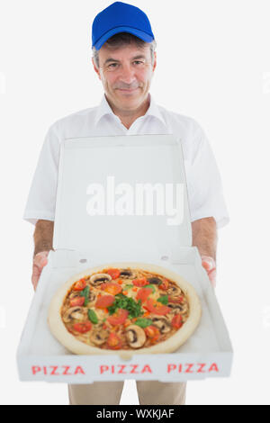 Portrait of mature man holding pizza against white background Banque D'Images