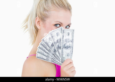 Closeup portrait of young woman holding attisa les billets en face de visage Banque D'Images