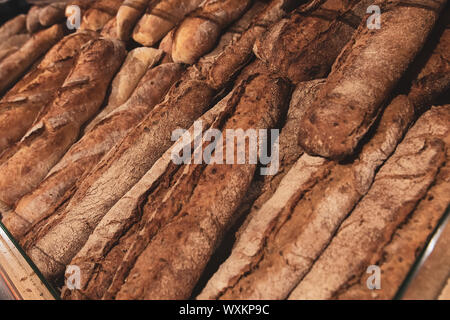 Baguettes de pain noir sur un plateau de pain dans une épicerie. Produits de boulangerie frais. Le pain de seigle. Banque D'Images