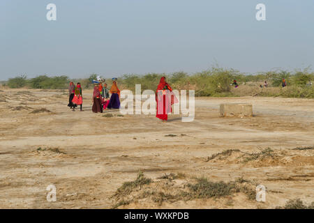 Groupe de femmes des tribus dans Fakirani chiffon traditionnel marche dans le désert, le grand désert du Rann de Kutch, Gujarat, Inde Banque D'Images