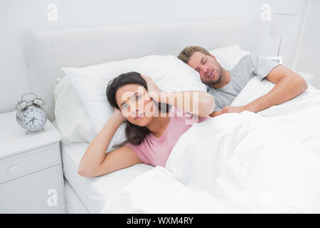 L'homme est le ronflement ennuyeux son épouse qui essaie de dormir dans son lit Banque D'Images