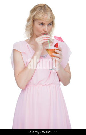 Attractive blonde drinking cocktail against white background Banque D'Images