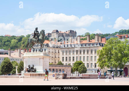 LYON, FRANCE - 14 juillet 2019 : Roi Louis XIV statue sur la Place Bellecour, dans le centre-ville de Lyon, avec des piétons qui passent. C'est la place principale Banque D'Images