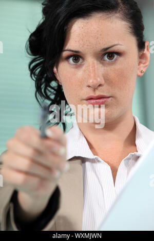 Gros plan sur une femme pointant son stylo Banque D'Images