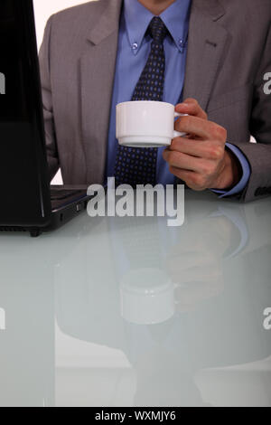 Businessman avec un café et un ordinateur portable Banque D'Images