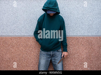 L'homme, adolescent holding grand couteau. La lutte contre la criminalité des gangs, la criminalité chez les jeunes... concept. Banque D'Images