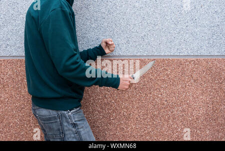 L'homme, adolescent holding grand couteau. La lutte contre la criminalité des gangs, la criminalité chez les jeunes... concept. Banque D'Images