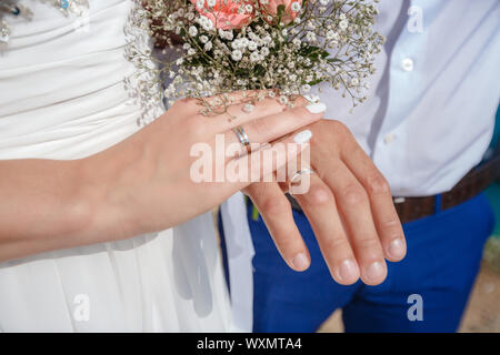 Senior couple holding hands and afficher les anneaux de mariage, bouquet de mariage sur l'autel de l'église. Les mains et les joints toriques de mariage bouquet Banque D'Images