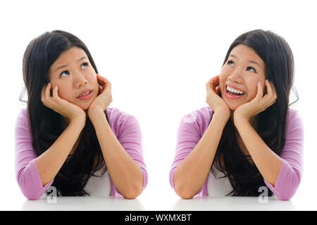 Triste et heureux face expression d'Asian Woman, hands holding face sitting isolé sur fond blanc. Banque D'Images