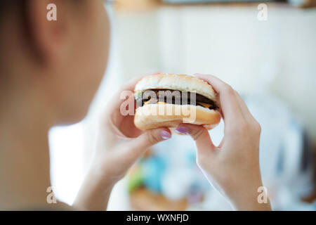 Woman eating hamburger. Vue arrière Banque D'Images