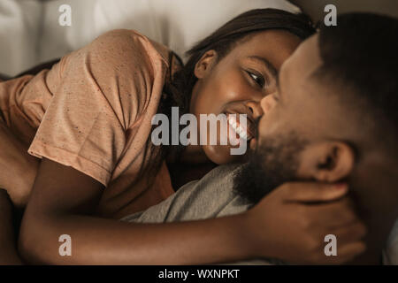 Affectioante young African American couple lying together in bed Banque D'Images