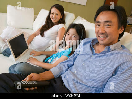 Family Relaxing in Living room with Laptop Banque D'Images