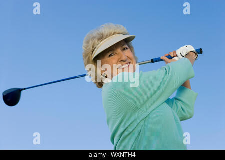 Woman Swinging Golf Club Banque D'Images