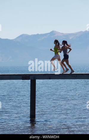 Women jogging sur la jetée au-dessus du lac pittoresque Banque D'Images