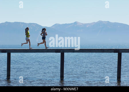 Women jogging sur la jetée au-dessus du lac pittoresque Banque D'Images