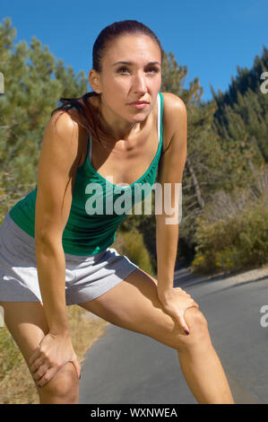 Femme prenant une pause au cours de son jogging Banque D'Images