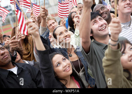 Personnes agitant des drapeaux américains Banque D'Images