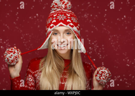Belle fille blonde dans une nouvelle image de l'année en chapeau chaud et chandail. Beauté Visage avec le maquillage de fête. Banque D'Images