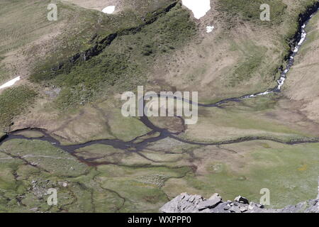 Vue aérienne de la fonte des neiges la création de petite rivière sur meadow en région montagneuse. Banque D'Images