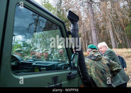 17 septembre 2019, la Saxe-Anhalt, Straßberg : Soldats de la 171 du bataillon logistique de Burg et le 172 bataillon logistique de Beelitz sont debout avec Egbert Thile (r), chef de l'office des forêts dans la région de Harz, au niveau de la cagoule d'un véhicule hors route de l'Armée Fédérale Allemande et discuter au sujet de la poursuite de l'action commune dans la semaine à venir. Les soldats sont les premiers enquêteurs des forces armées allemandes à se renseigner sur leur prochain déploiement de la région et de la forêt privée. Les Forces armées allemandes à être déployées contre le bostryche peste dans les montagnes du Harz Photo : K Banque D'Images