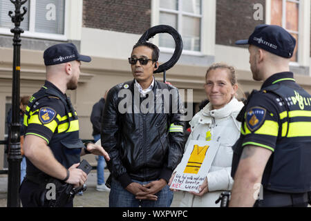 Les protestataires sont convoqués par la police à quitter la foule qui attendent l'entraîneur d'or avec le roi et la reine néerlandaise sur Prinsjesdag Banque D'Images