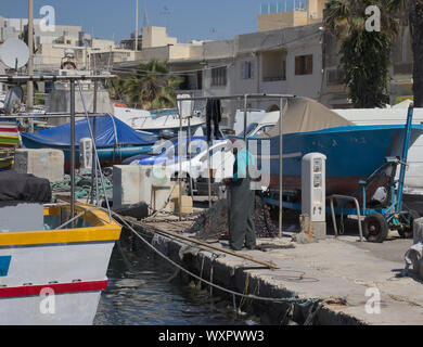 MARSAXLOKK, MALTE - Mai 2019 : préparation du pêcheur maltais filets pour la pêche quotidienne. Banque D'Images