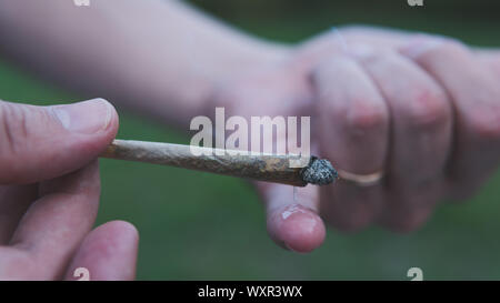 Les hommes de mains tenant conjoint marijuana, cannabis blunt à l'extérieur. Le cannabis est un concept de médecine de fines herbes Banque D'Images