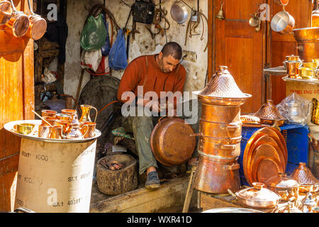 L'homme à un atelier/usine de production de produits en cuivre fait main, pots, bidons casseroles dans de nombreux styles différents, Fès, Maroc Banque D'Images