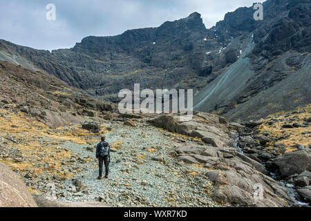 L'approche d'un déambulateur Coire Lagan avec MhicChoinnich Sgurr et la grande pierre au-dessus de la tige. Dans les montagnes Cuillin, Isle of Skye, Scotland, UK Banque D'Images