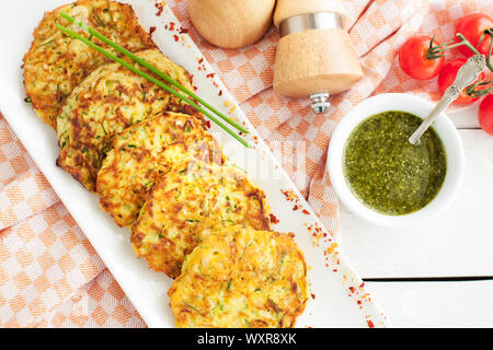 Des galettes de courgettes aux fines herbes, servi avec le pesto. Dîner santé Banque D'Images