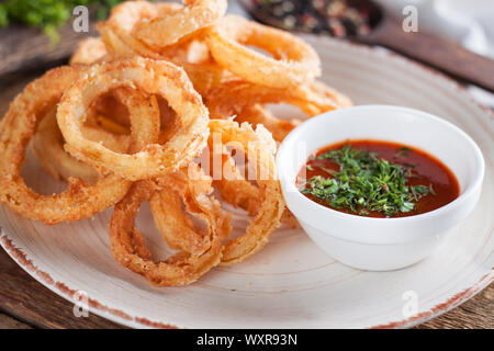 Croustillant d'oignon frit fait maison avec une sauce tomate Banque D'Images